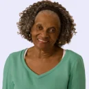 Mulher negra de terceira idade sorrindo para a camera